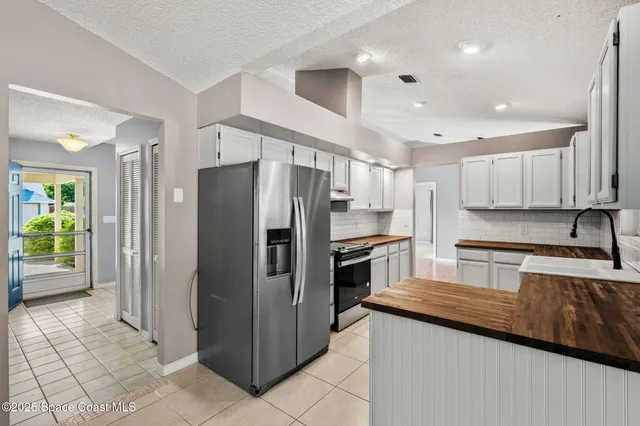 a kitchen with granite countertop a refrigerator and a sink