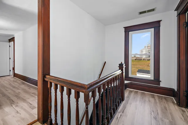 a view of a hallway with wooden floor and stairs