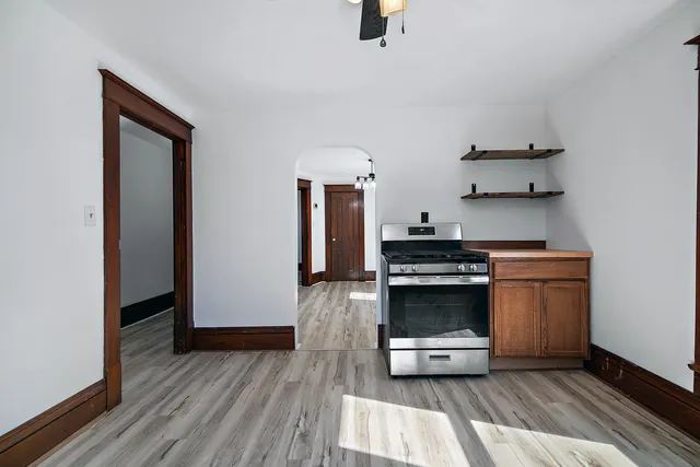 a kitchen with kitchen island a stove and a wooden floor