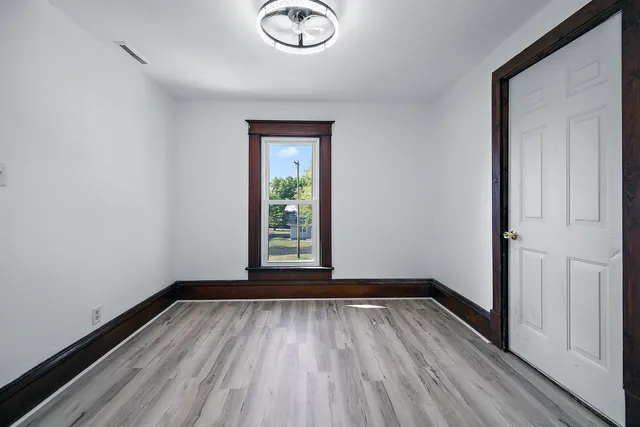 a view of a room with wooden floor and window