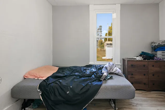 a bedroom with a bed and a lamp on dresser