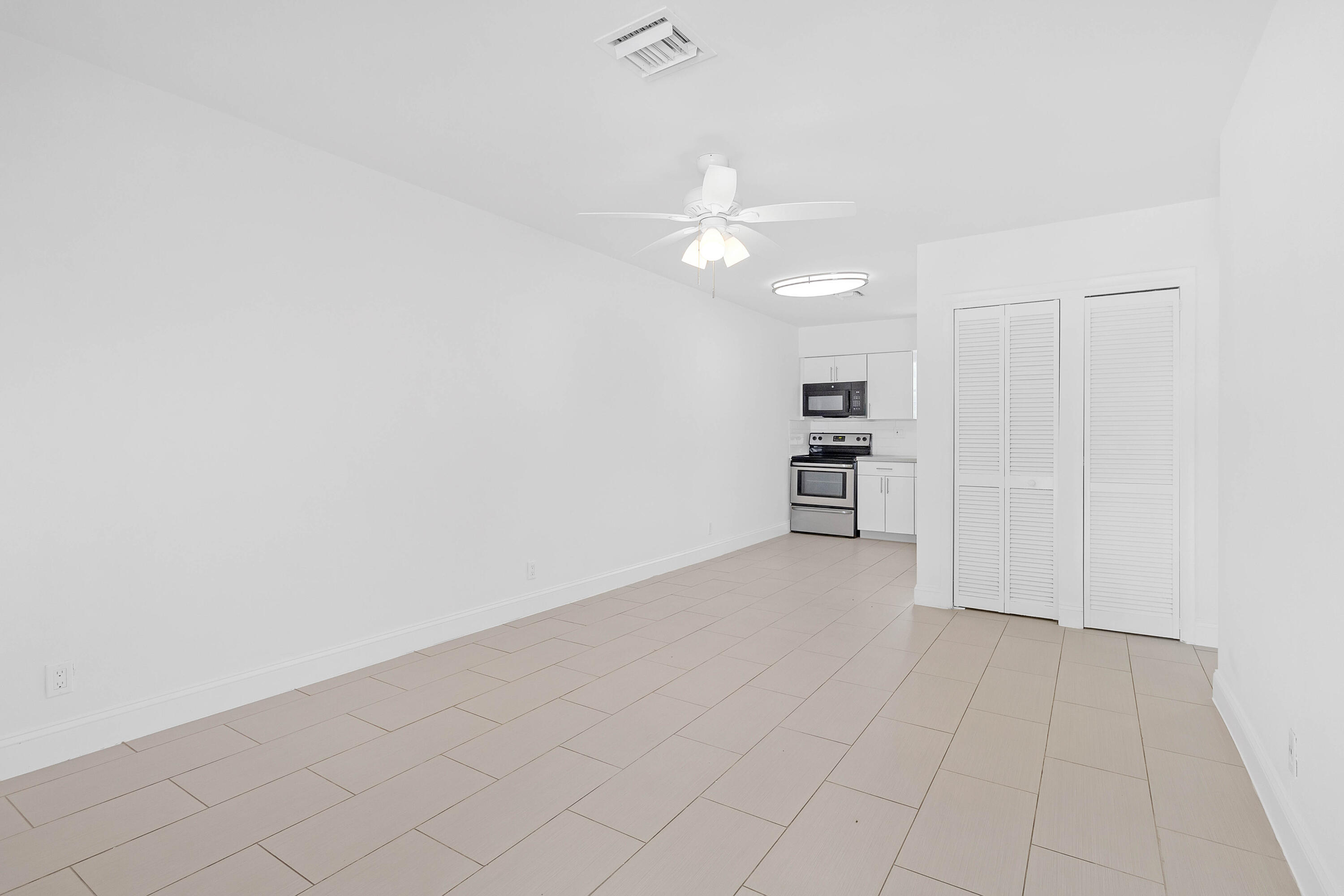 330 West Camino Real Boca Raton, FL 33432 - Photo 7 of 18 an empty room with kitchen view and a refrigerator