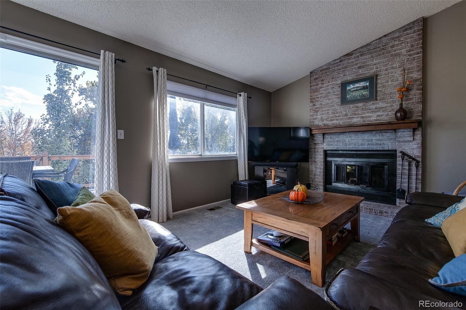 462 Mountain Chickadee Road Highlands Ranch, CO 80126 - Photo 12 of 37 a living room with furniture and a fireplace