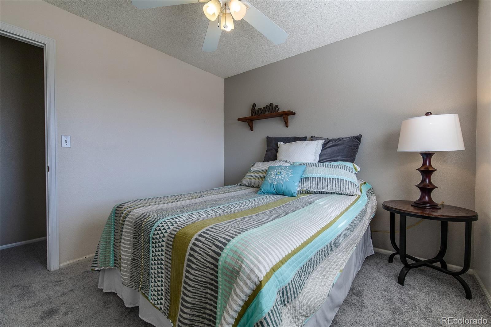 462 Mountain Chickadee Road Highlands Ranch, CO 80126 - Photo 18 of 37 a bedroom with a bed and a lamp