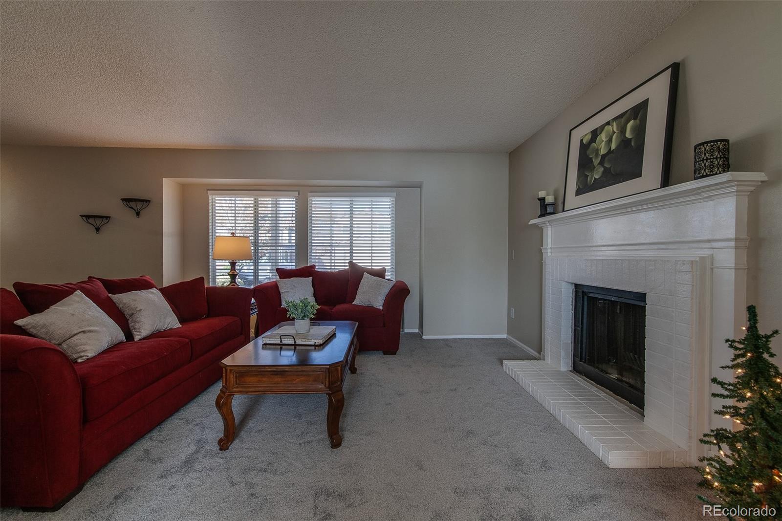 462 Mountain Chickadee Road Highlands Ranch, CO 80126 - Photo 5 of 37 a living room with furniture and a fireplace