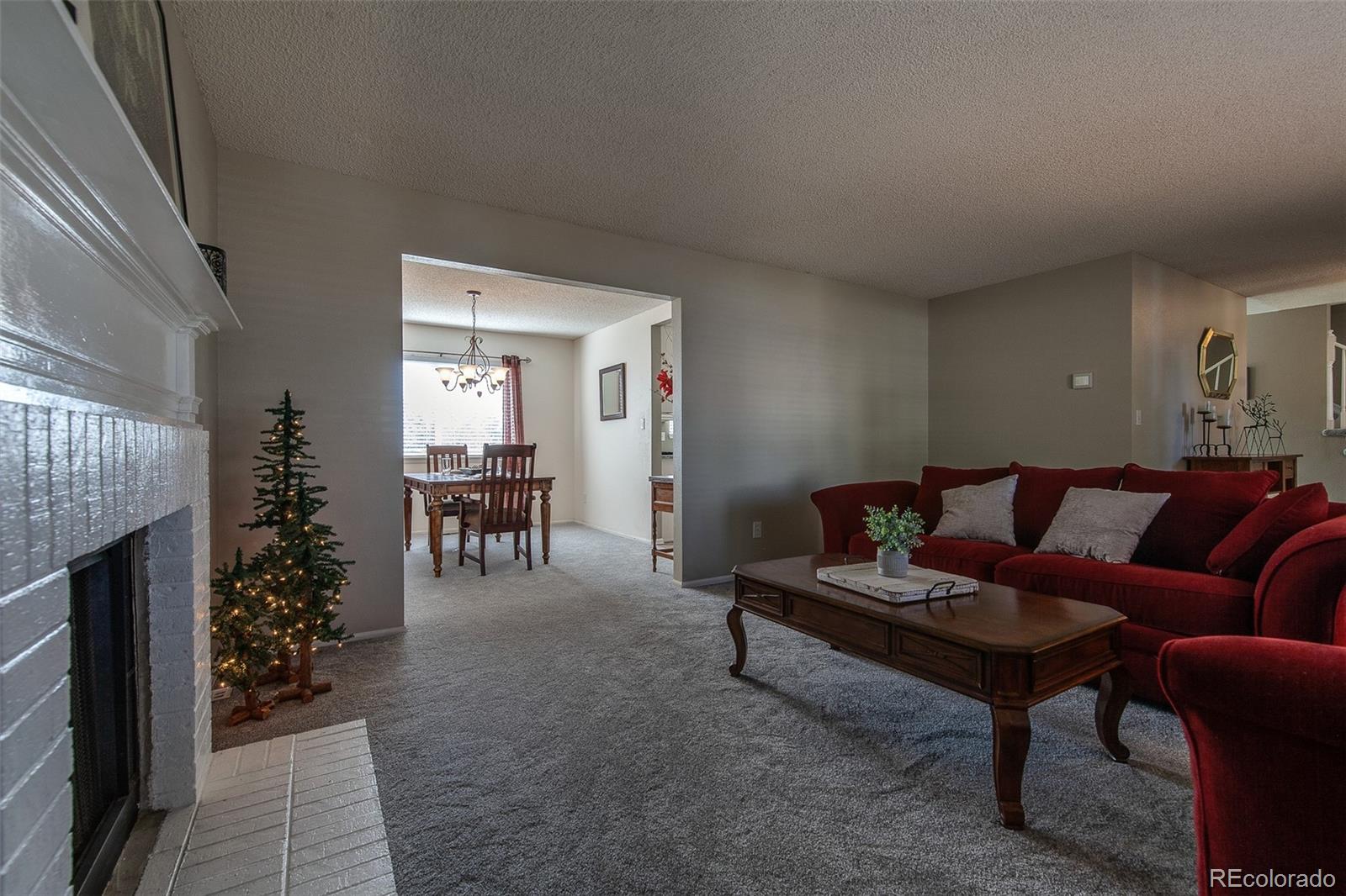 462 Mountain Chickadee Road Highlands Ranch, CO 80126 - Photo 6 of 37 a living room with furniture and a fireplace