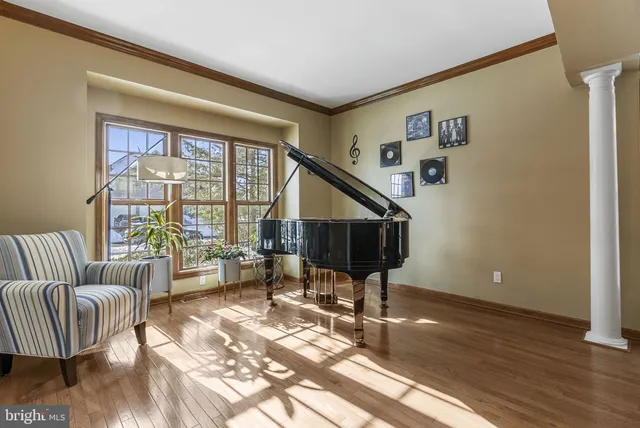 a view of a hallway to a livingroom with wooden floor and stairs