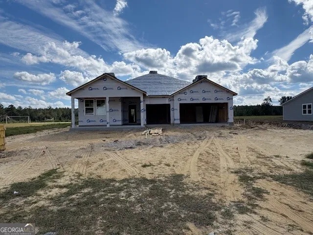 a front view of a house with a yard and potted plants