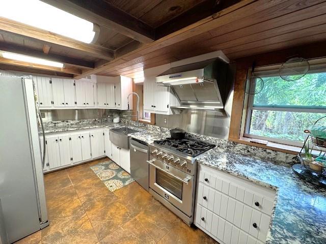 1302 Southeast Wacahoota Road Micanopy, FL 32667 - Photo 9 of 67 a kitchen with stainless steel appliances granite countertop a stove a sink dishwasher and white cabinets with wooden floor