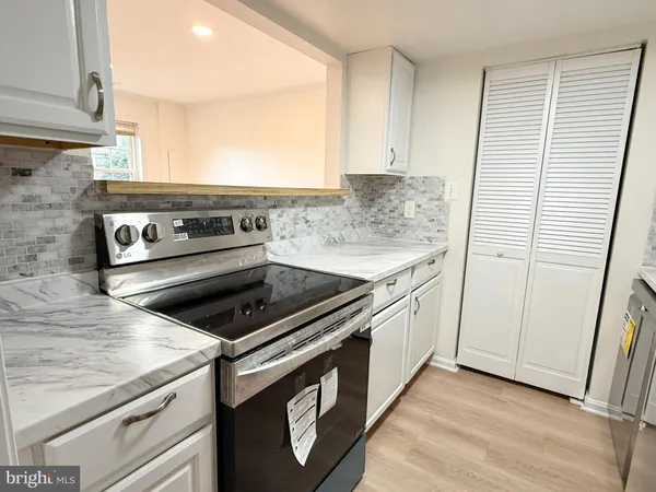 a kitchen with a refrigerator sink stove and cabinets