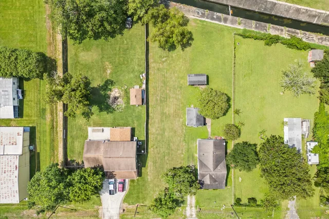 an aerial view of a house with a garden and lake view