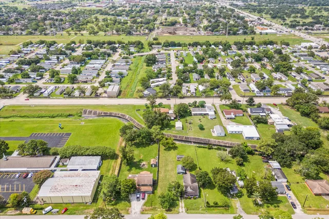 an aerial view of residential houses with outdoor space and trees