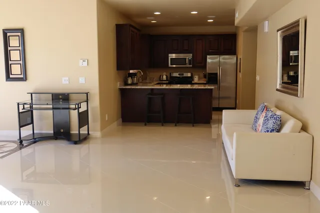 a kitchen with stainless steel appliances kitchen island granite countertop a refrigerator and a stove top oven