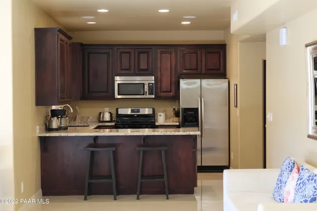 a kitchen with stainless steel appliances granite countertop a stove a sink dishwasher a refrigerator and a microwave oven