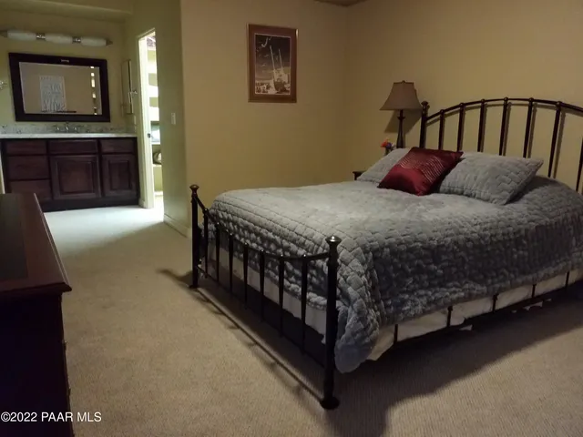 a bedroom with a bed and a mirror on dresser