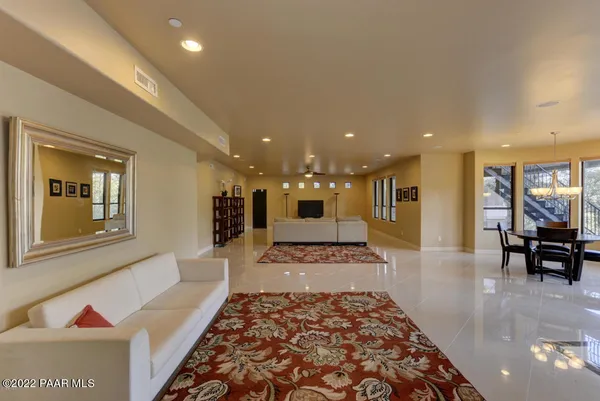 a large living room with stainless steel appliances furniture a rug and a view of kitchen