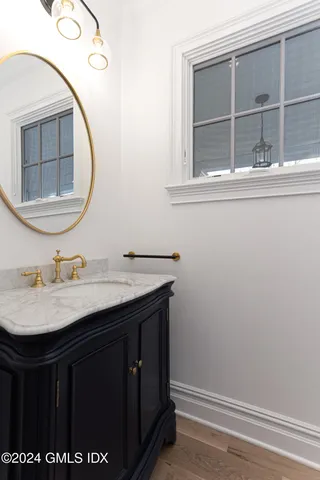 a room with lots of white furniture and wooden floor