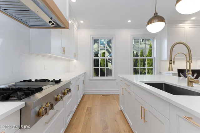 a view of a living room hardwood and kitchen with furniture appliances
