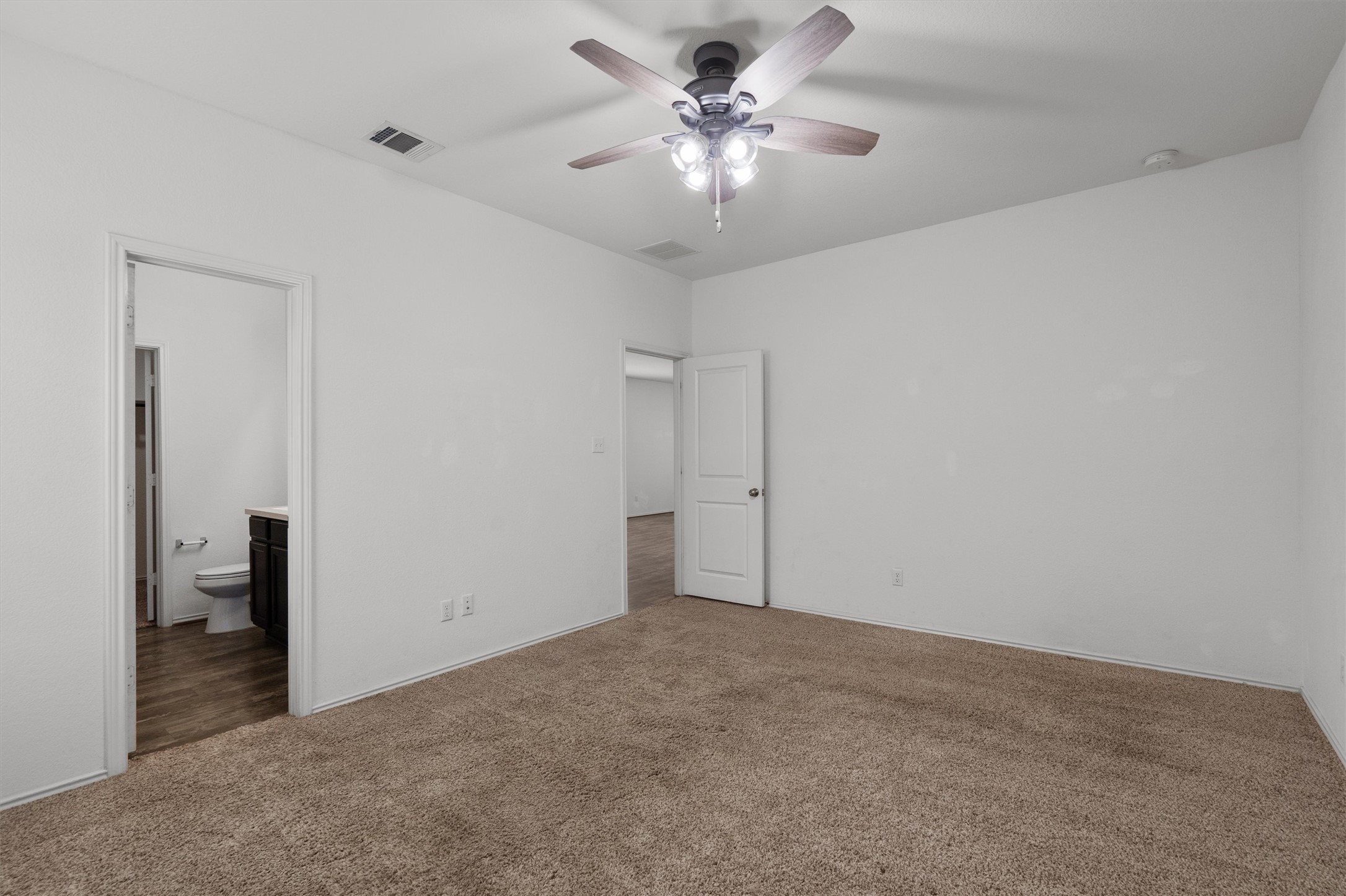 791 Circle Way Jarrell, TX 76537 - Photo 16 of 36 Carpeted bedroom featuring a ceiling fan with integrated lighting, white walls, and a white interior door