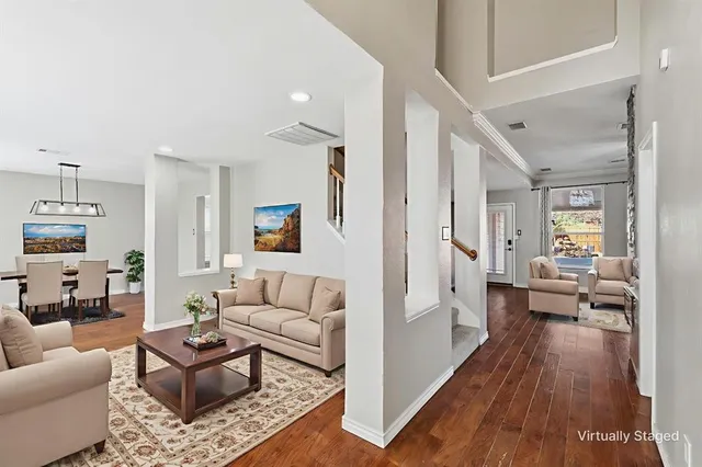 a living room with furniture and a wooden floor
