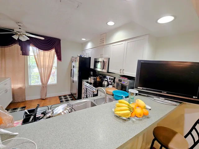 a room with furniture pool table flat screen tv and windows