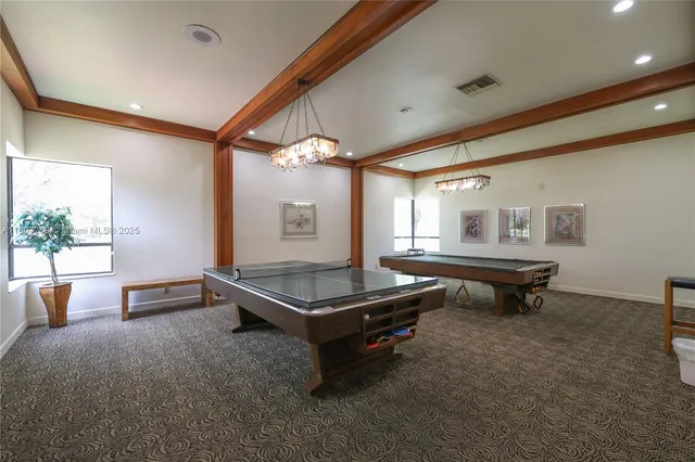 a room with pool table and windows