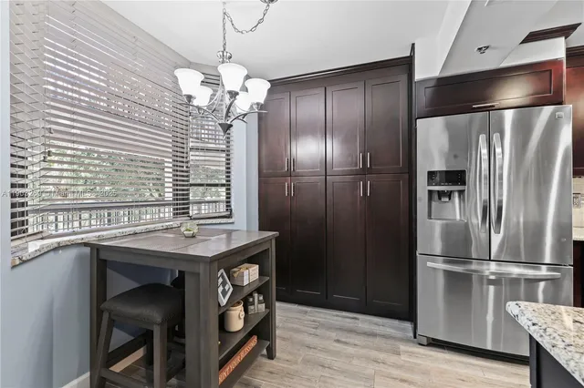a kitchen with stainless steel appliances granite countertop a refrigerator a sink and a stove