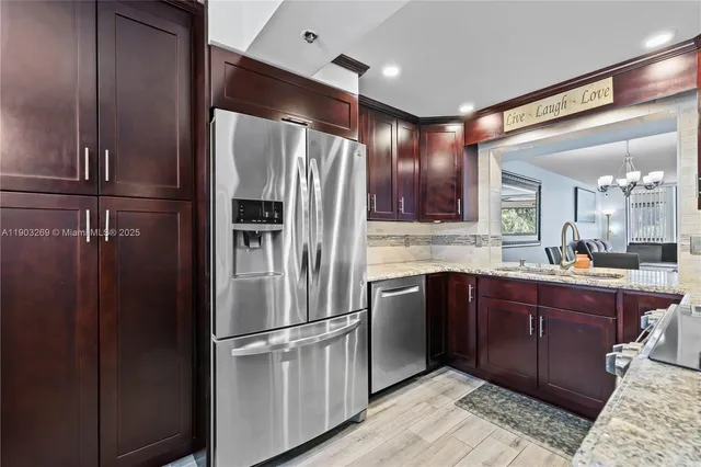 a kitchen with stainless steel appliances granite countertop a refrigerator and a sink