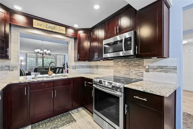 a kitchen with stainless steel appliances granite countertop wooden cabinets and a sink