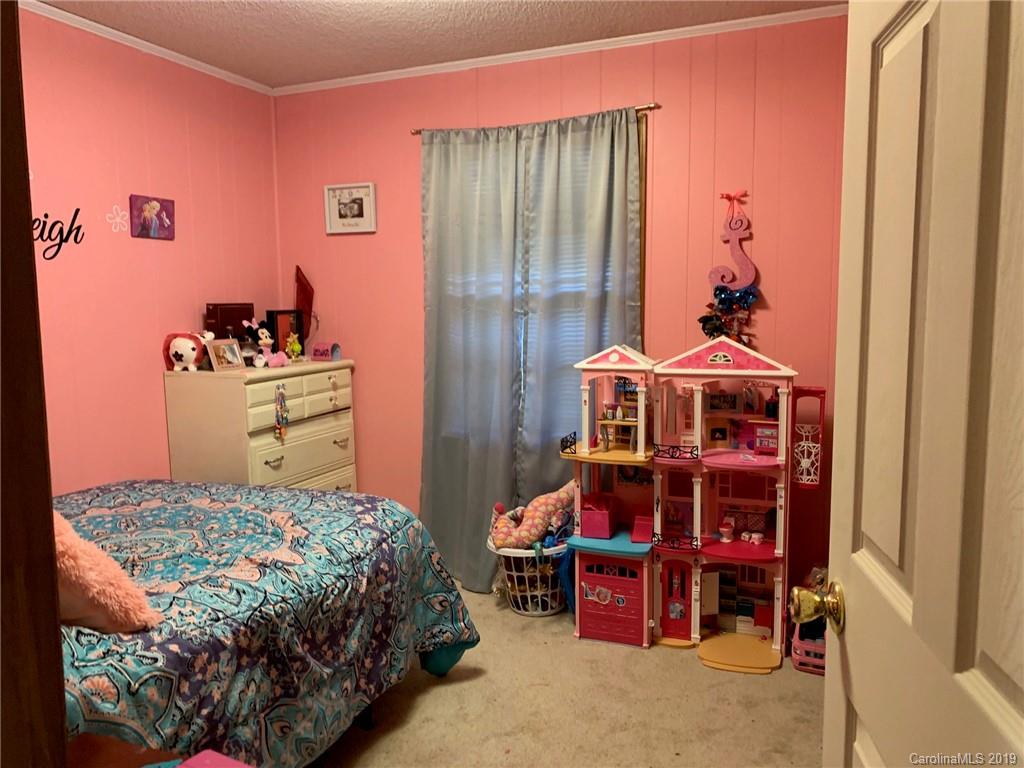 530 South Potter Road Lancaster, SC 29720 - Photo 19 of 21 a bedroom with a bed and a chandelier