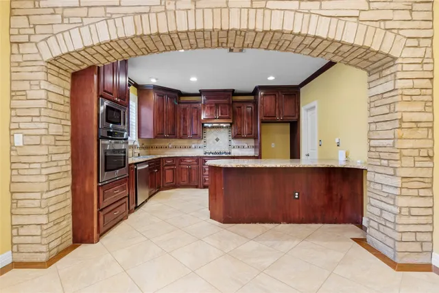 a kitchen with stainless steel appliances granite countertop a stove microwave and refrigerator