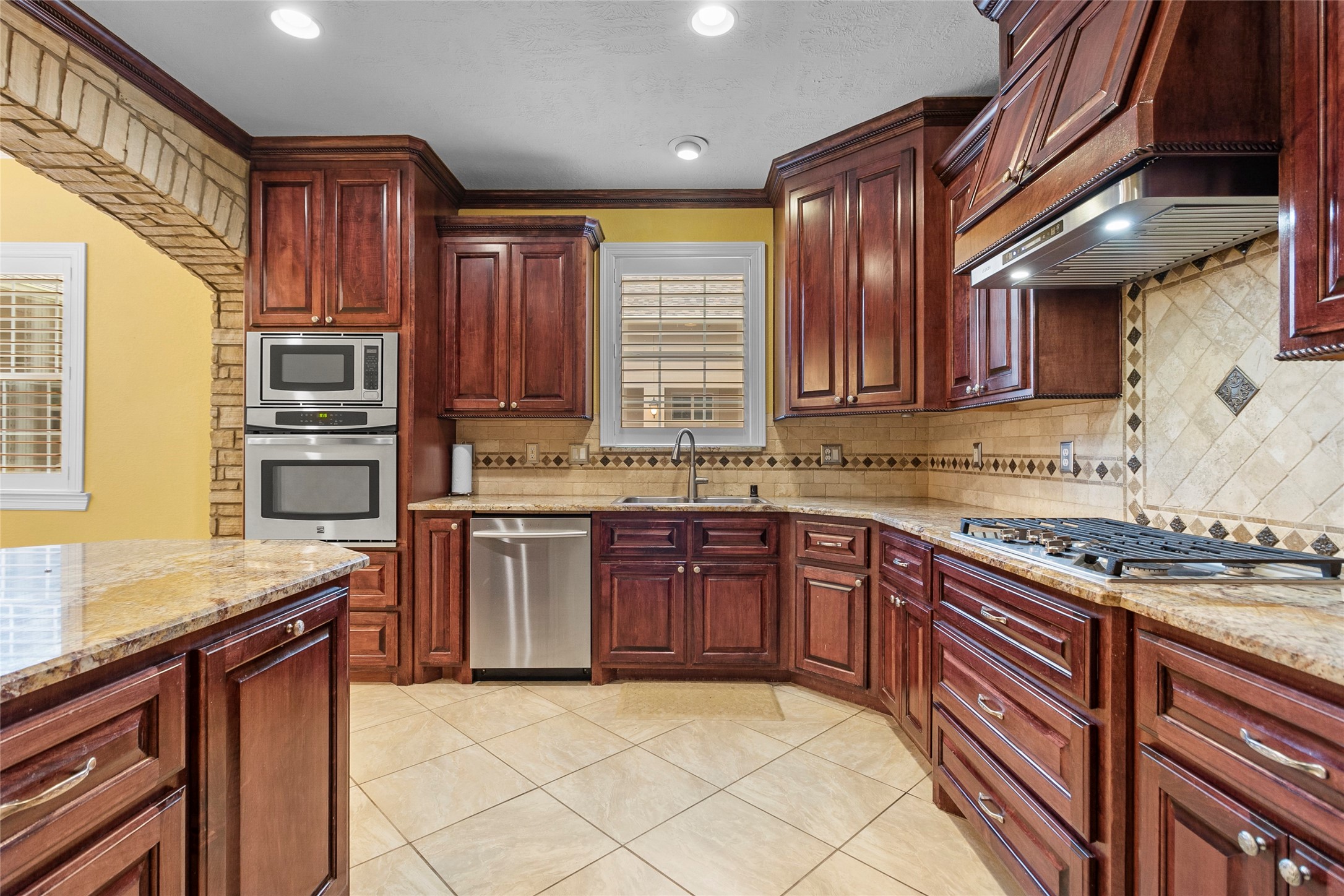 22321 Mossy Oaks Road Spring, TX 77389 - Photo 17 of 50 a kitchen with stainless steel appliances granite countertop wooden cabinets a stove top oven a granite counter space and a window