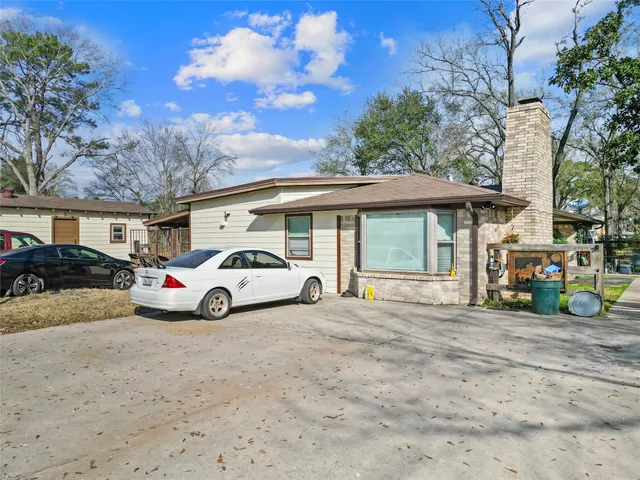 a view of a yard in front of a house with a large tree