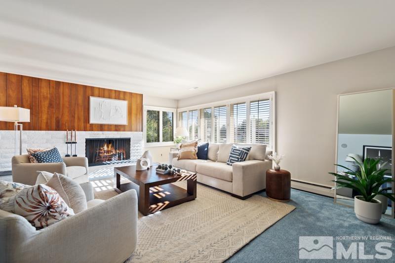 a living room with furniture large window and a fireplace