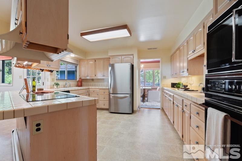 2301 Crescent Circle Reno, NV 89509 - Photo 8 of 40 a kitchen with stainless steel appliances granite countertop a refrigerator a stove a sink dishwasher and white cabinets with wooden floor