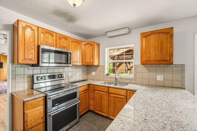 a kitchen with stainless steel appliances granite countertop a sink stove and microwave