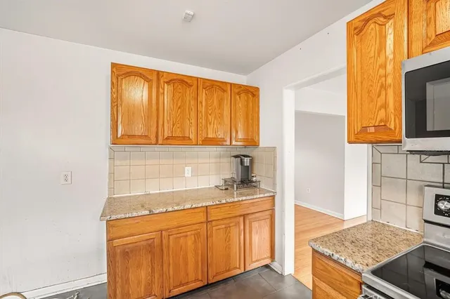 a kitchen with granite countertop sink stove and cabinets