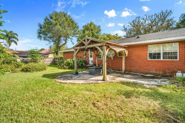 a view of a house with backyard and tree