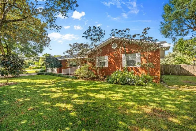 a view of a big house with a big yard and large trees