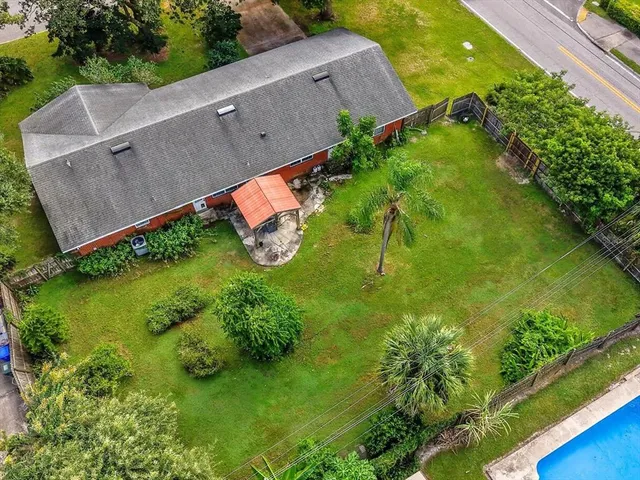 an aerial view of a house with a yard and lake view
