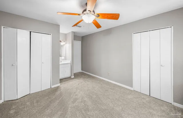 a view of a room with a ceiling fan and shower