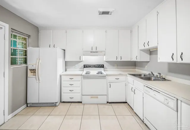 a kitchen with white cabinets and white appliances