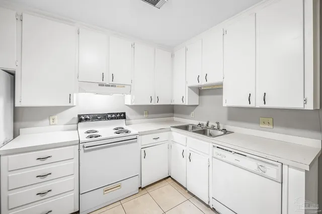a kitchen with cabinets appliances a sink and a stove