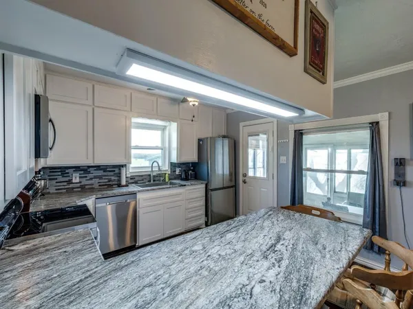 a kitchen with stainless steel appliances granite countertop a stove and a refrigerator