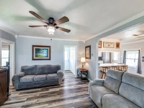 a living room with furniture and a wooden floor