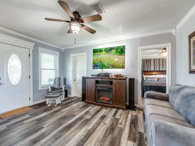 a living room with furniture a fireplace and a flat screen tv