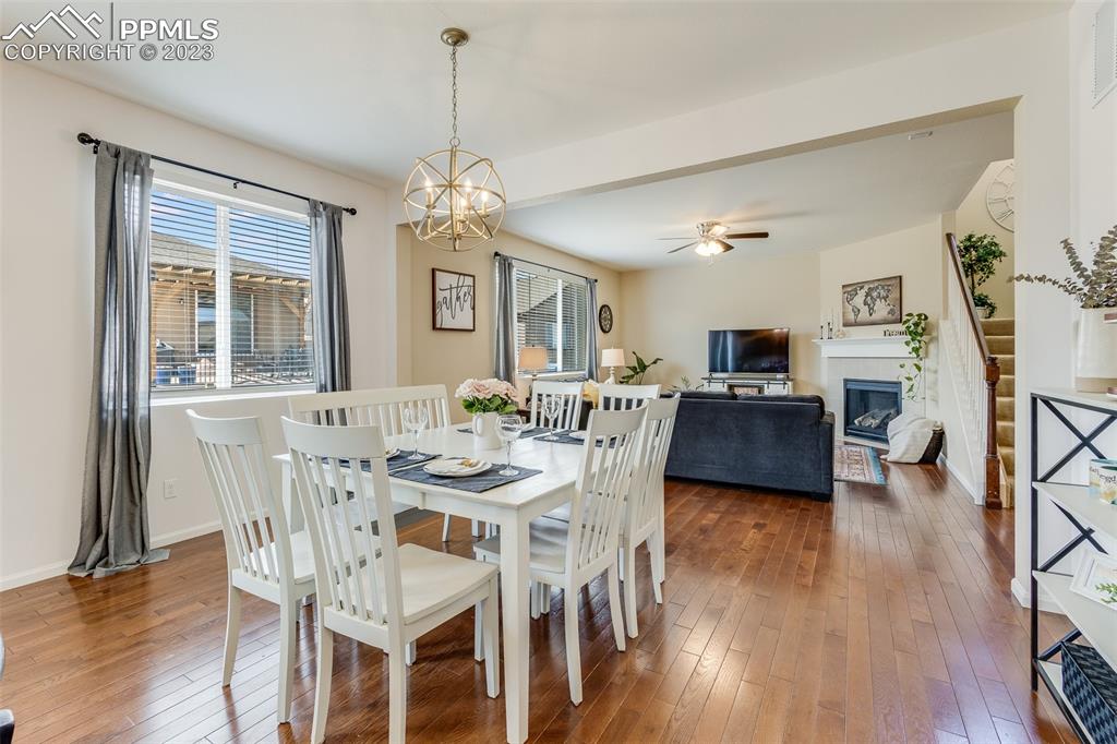 7122 Golden Acacia Lane Colorado Springs, CO 80927 - Photo 11 of 37 a view of a dining room with furniture a chandelier and wooden floor