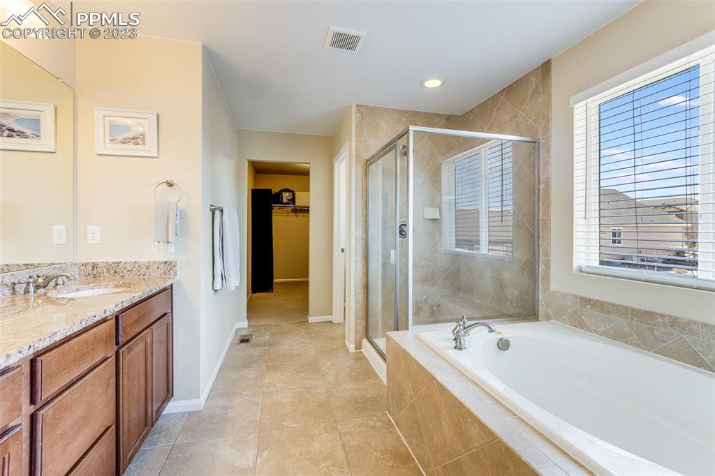 7122 Golden Acacia Lane Colorado Springs, CO 80927 - Photo 18 of 37 a bathroom with a granite countertop tub shower and sink