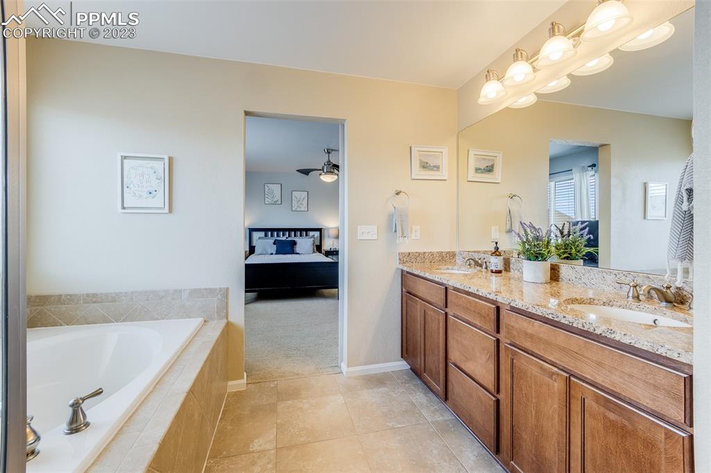 7122 Golden Acacia Lane Colorado Springs, CO 80927 - Photo 19 of 37 a spacious bathroom with a tub sink and mirror