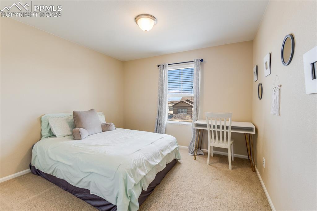 7122 Golden Acacia Lane Colorado Springs, CO 80927 - Photo 21 of 37 a bedroom with a bed a table and chair